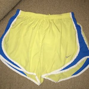 Yellow Nike shorts with blue and white trim